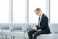 Businessman reading a business document sitting in the office lobby Royalty Free Stock Photo