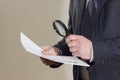 Businessman reading a document through magnifying glass