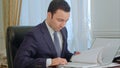 Businessman reading documents and talking on landline phone Royalty Free Stock Photo