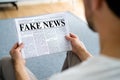 Businessman Reading Fake News Article On Newspaper