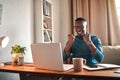 Businessman reading good news on a laptop, looking excited and happy after a loan approval, winning a reward or an