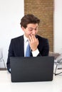 Businessman reading his laptop with a snigger