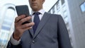 Businessman reading news on smartphone, convenient quick access to information