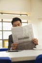 Businessman reading newspaper in company cafeteria Royalty Free Stock Photo