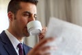 Businessman reading newspaper and drinking coffee Royalty Free Stock Photo