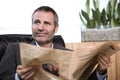 Businessman reading newspaper and looking up. Royalty Free Stock Photo