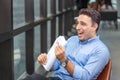 Businessman reading newspaper over office building. Businessman happy smiling after reading goods news. Man goot a new job