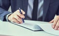 Businessman reading rental contract before making a deal. Corporate man with pen in hand working in modern office Royalty Free Stock Photo