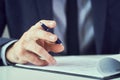 Businessman reading rental contract before making a deal. Corporate man with pen in hand working in modern office Royalty Free Stock Photo