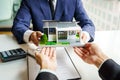 Businessman real estate agent giving modern house model to house owner after agree to buy a new home Royalty Free Stock Photo