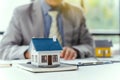 Businessman realtor with house model, sitting at desk, real estate agent manager working on documents, mortgage and property Royalty Free Stock Photo