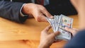 Businessman reciving money United States Dollars bills to corruption from his partner in business at working desk - bribery Royalty Free Stock Photo