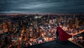 Businessman with red cape standing on the rooftop