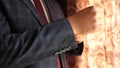 Businessman in red tie dark blue check suit straightens sleeve of white shirt. dark blue check suit. office worker gets