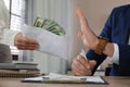 Businessman rejecting bribe at table in office, closeup