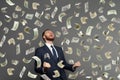 Businessman rejoicing for his success with hundred dollar banknotes flying in the air Royalty Free Stock Photo