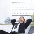 Businessman relaxes sitting behind a Desk