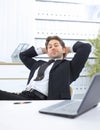 Businessman relaxes sitting behind a Desk