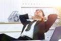 Businessman relaxes sitting behind a Desk