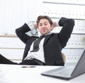 Businessman relaxes sitting behind a Desk