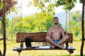 Businessman relaxes after working on laptop sitting in lotus pose outdoors.