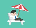 Businessman relaxing on beach chair with umbrella Royalty Free Stock Photo