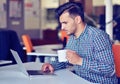 Businessman relaxing with legs up on desk, drinking coffee while dreaming about future at workplace in modern office. Royalty Free Stock Photo