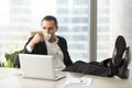 Businessman relaxing and drinking coffee at workplace in office. Royalty Free Stock Photo