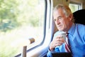 Businessman Relaxing On Train With Cup Of Coffee Royalty Free Stock Photo