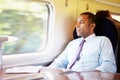 Businessman Relaxing On Train Listening To Music Royalty Free Stock Photo