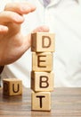 Businessman removes wooden blocks with the word Debt. Reduction or restructuring of debt. Bankruptcy announcement. Refusal to pay Royalty Free Stock Photo