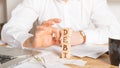 Businessman removes wooden blocks with the word Debt. Reduction or restructuring of tax. Bankruptcy announcement. Refusal to pay Royalty Free Stock Photo