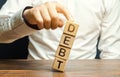 Businessman removes wooden blocks with the word Debt. Debt relief or cancellation is the partial or total forgiveness of debts, or