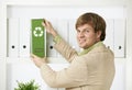 Businessman removing green folder from shelf