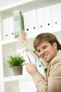 Businessman removing green folder from shelf Royalty Free Stock Photo