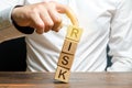 Businessman rescues with his finger a tower of cubes with the word Risk from falling Risk management, cost assessment, business