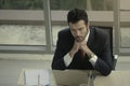 Businessman resting chin on hands seriously thinking about job on messy desk at office desk conference meeting room in office 