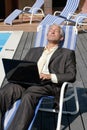 Businessman resting on deck chair Royalty Free Stock Photo
