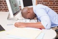 Businessman resting head on computer keyboard in office Royalty Free Stock Photo