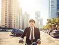 Businessman riding bicycle to work on urban street at morning Royalty Free Stock Photo