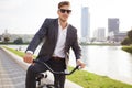 Businessman riding bicycle to work on urban street in morning. Royalty Free Stock Photo