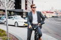 Businessman riding bicycle to work on urban street in morning. Royalty Free Stock Photo