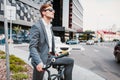 Businessman riding bicycle to work on urban street in morning. Royalty Free Stock Photo