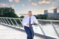 Businessman riding an electric scooter over a bridge