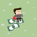 Businessman riding flying money.