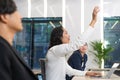 Businessman rises hand up for the question in the diverse employees business people team group. The colleagues discussing and