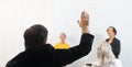 Businessman rises hand up for the question in the diverse employees business people team group. The colleagues discussing and