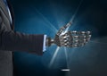 Businessman with robot hand against dark blue background and white light