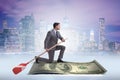 The businessman rowing on dollar boat in business financial concept