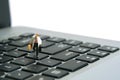 A businessman running above keyboard notebook laptop carrying briefcase. Isolated on white background Royalty Free Stock Photo